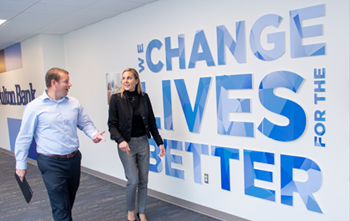 two people walking in front of a wall that says change lives for the better