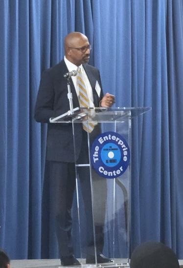 A man speaking at a podium at the Enterprise Center