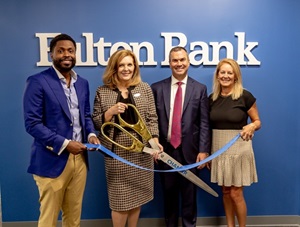 Four people at a ribbon cutting