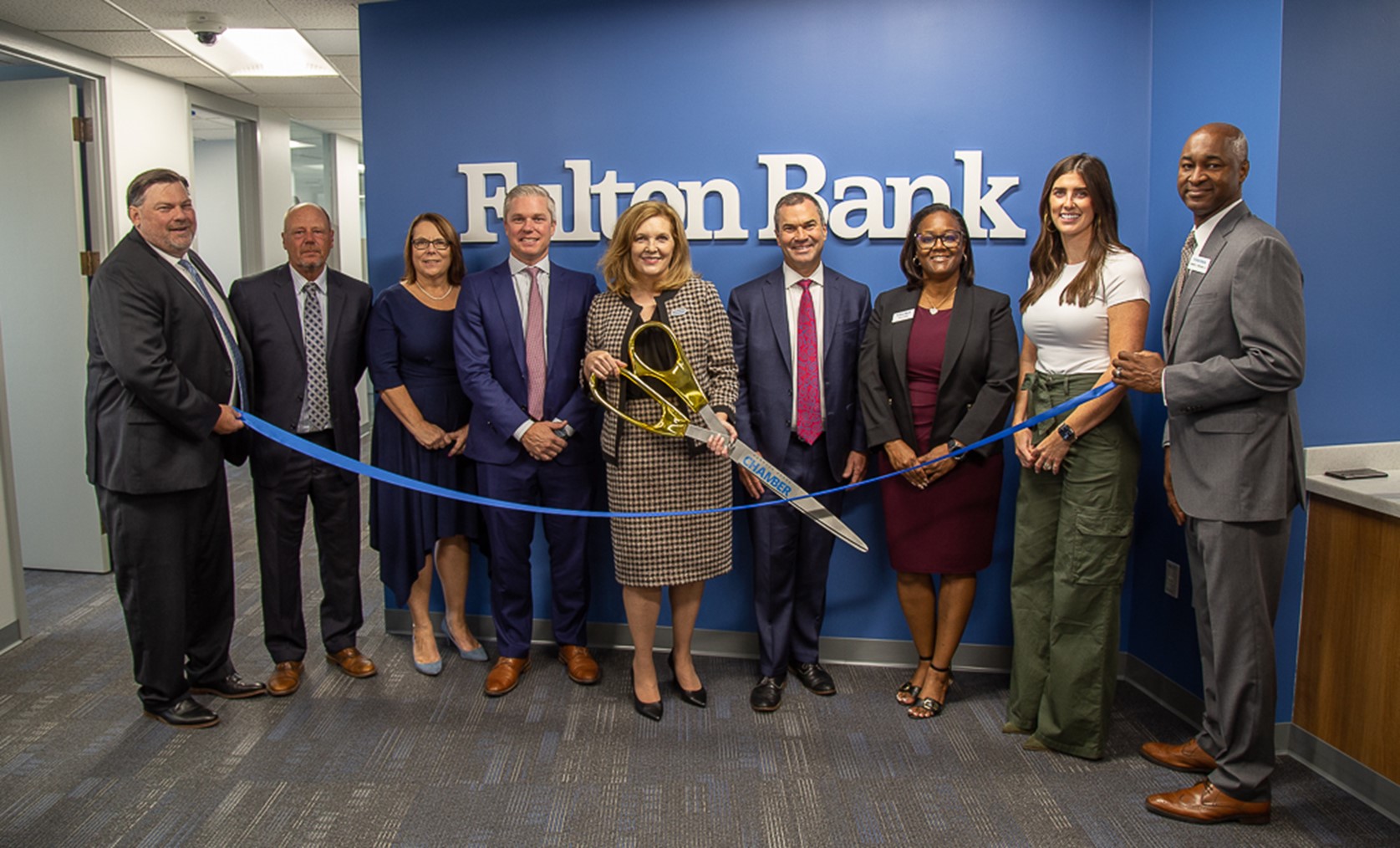 a group of business professionals celebrating the opening of a new office